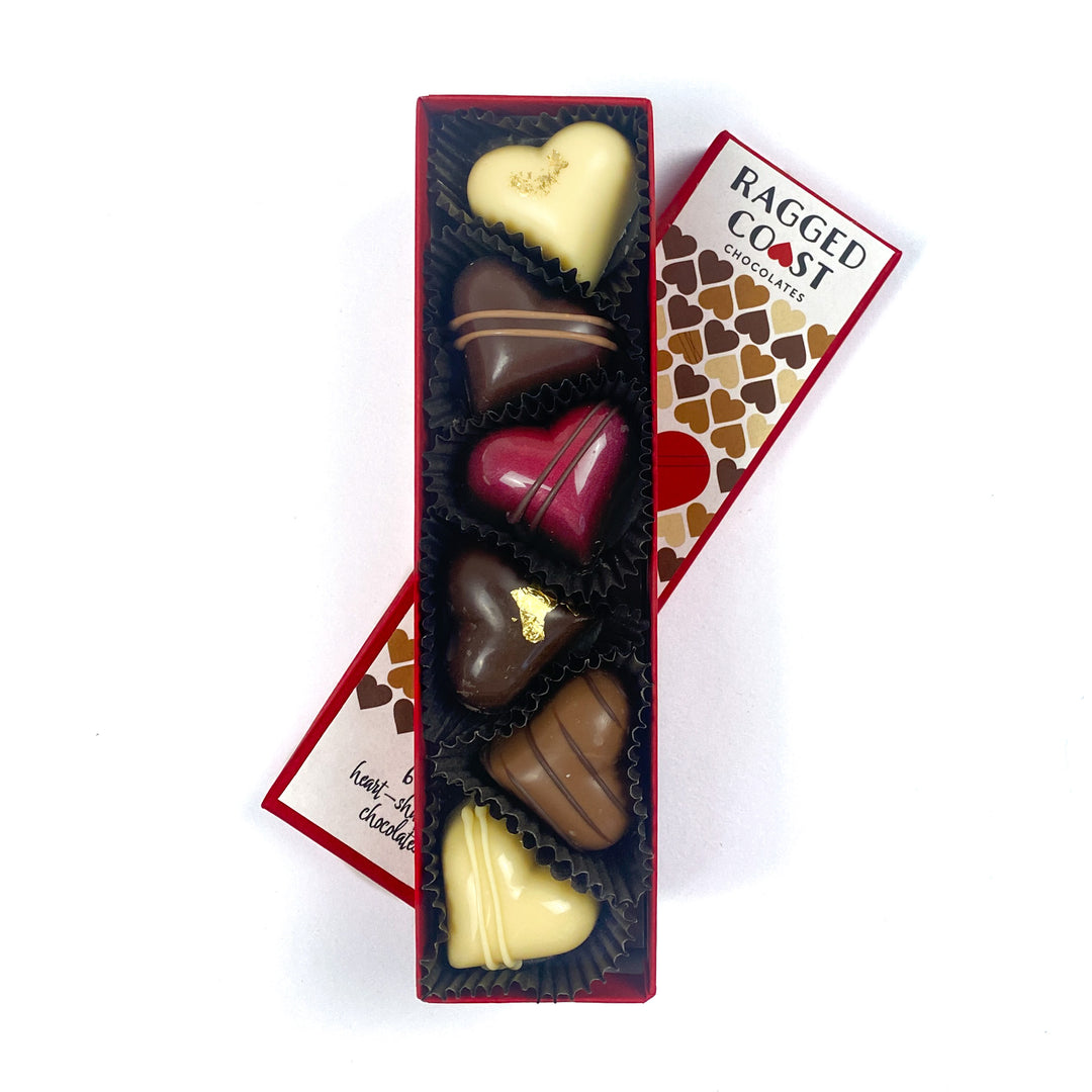 The "You're All Heart" gift box by Ragged Coast Chocolates is an elegant, rectangular package showcasing five delectable, assorted heart-shaped truffles with various designs.