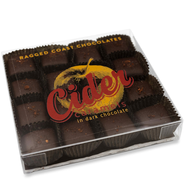 A clear plastic box contains 15 pieces of New England Cider Caramels in bittersweet chocolate. The label reads "Ragged Coast Chocolates New England Cider Caramels in Bittersweet Chocolate.