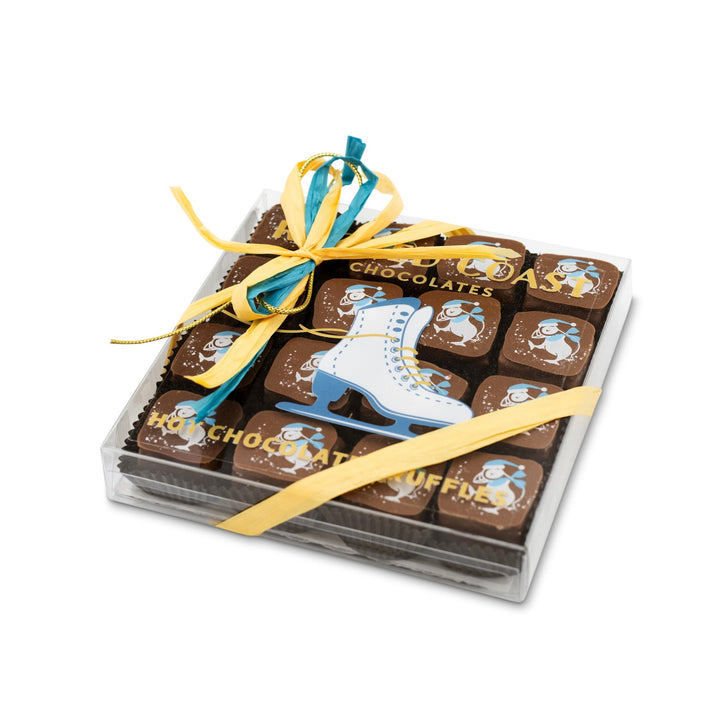 The Ragged Coast Chocolates "Hot Chocolates" for the Holidays is a box of chocolates decorated with a blue and white ice skate and yellow ribbons, containing delightful truffles accompanied by images of penguins wearing ice skates.