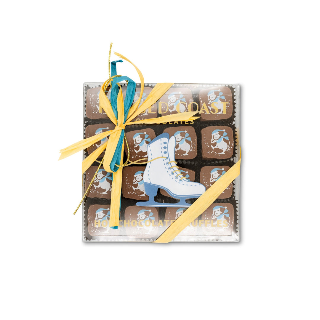 The Ragged Coast "Hot Chocolates" for the Holidays by Ragged Coast Chocolates is packaged with a blue and yellow ribbon, adorned with a delicate ice skate design on top, and includes decadent chocolate ganache truffles.