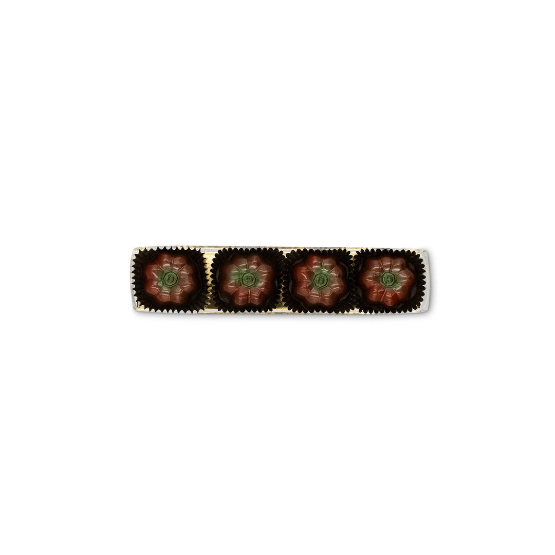 A row of four Pumpkin Patch Chocolate Truffles by Ragged Coast Chocolates, each elegantly wrapped in golden foil, arranged in a straight line against a white background.