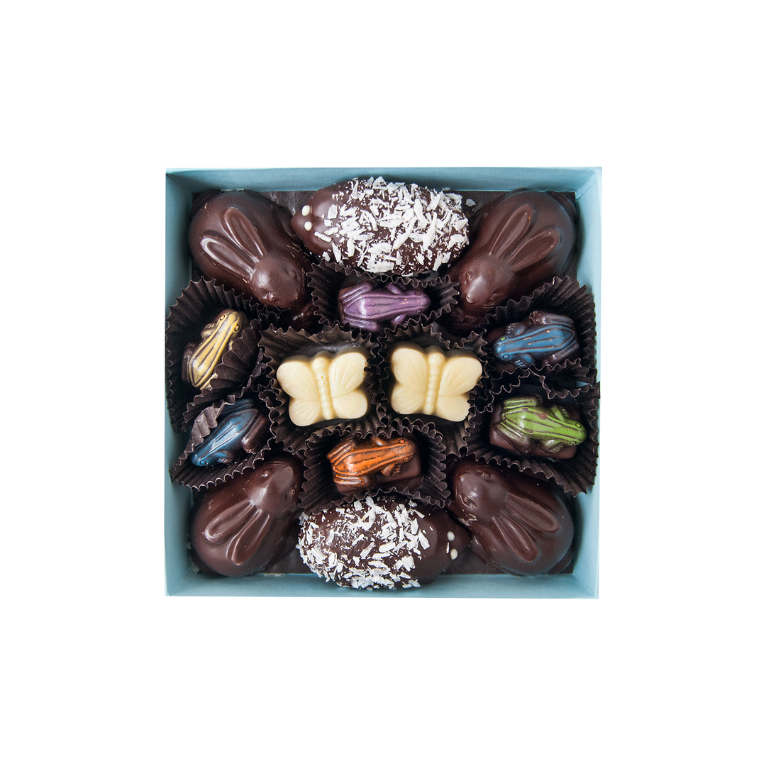 A box of Ragged Coast Chocolates' Springtime Woodland Collection with various fillings, decorations, and Marshmallow Bunnies.